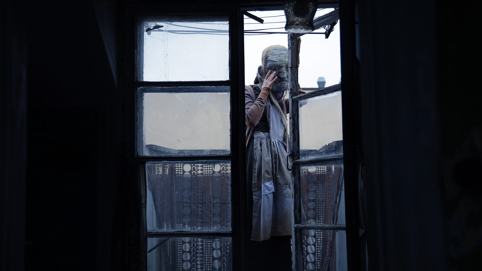A theatrical character leaning through an old window